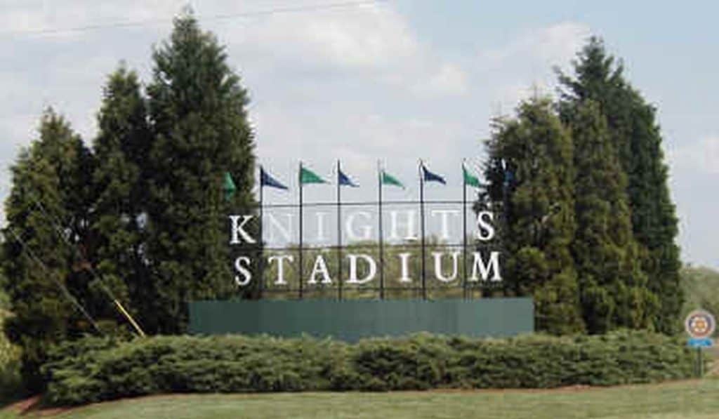 Sign of the Knights Stadium surrounded by trees.