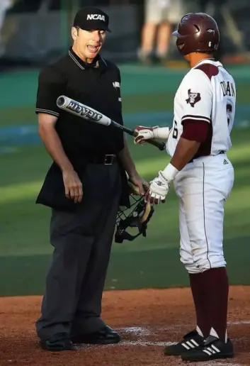 Umpire checks composite bat.
