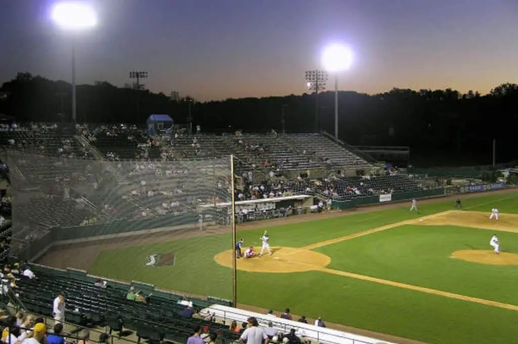 Baseball field floodlit in the evening.