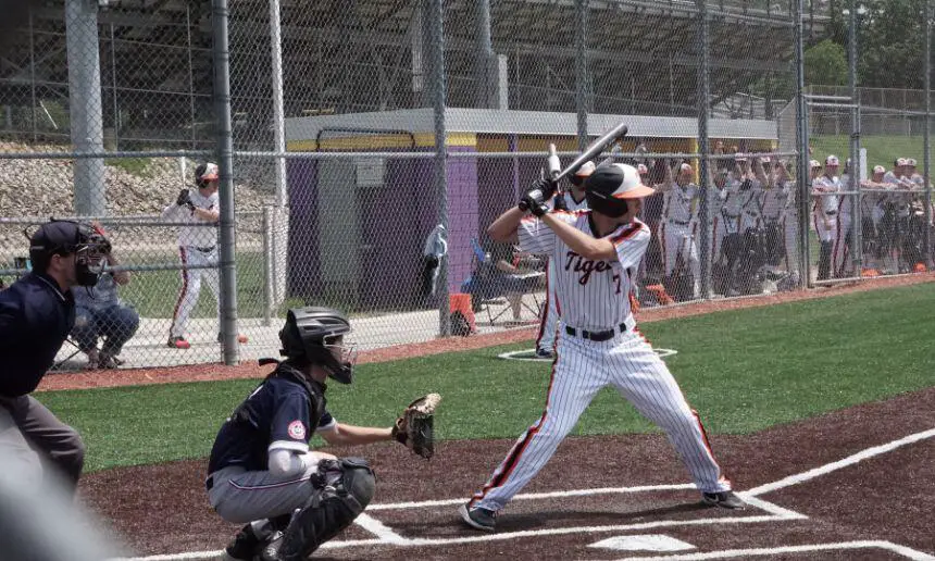 Baseball player hitting a ball with a bbcor bat.