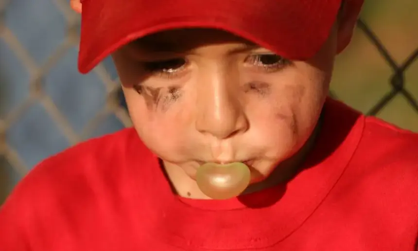 Young baseball player chewing a gum.