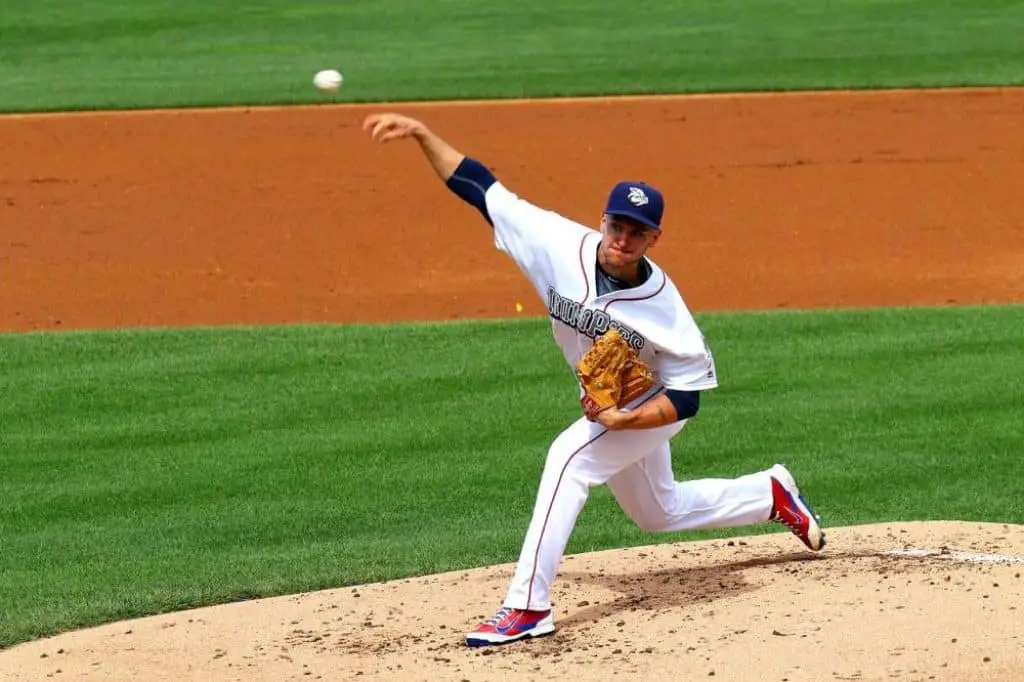 Baseball player with elbow guard pitching a ball.