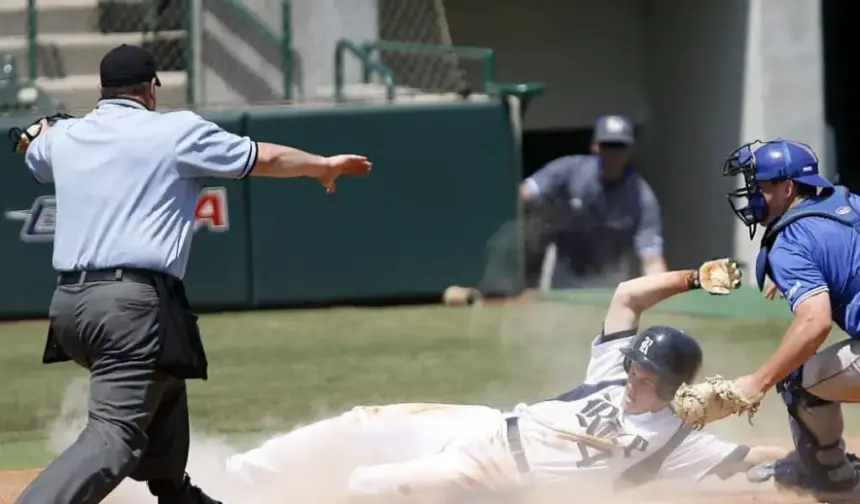 Baseball player sliding in the dirt.