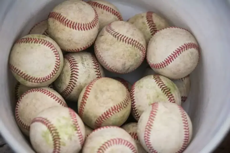 Bucket of used, dirty baseballs.