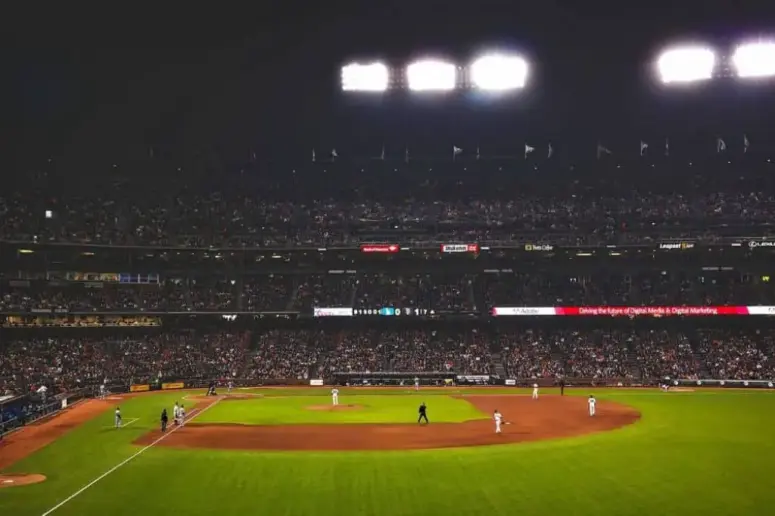Stadium lights shine on a baseball field.