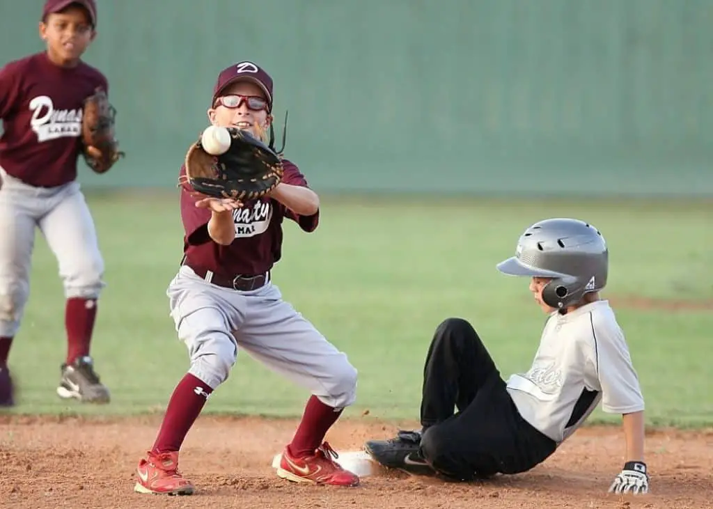 Kids playing baseball at a little league game.