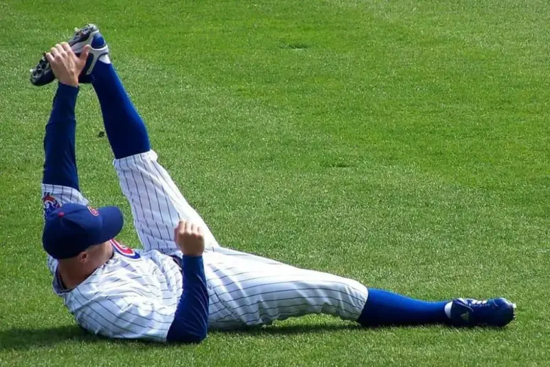 Baseball player stretching before game.