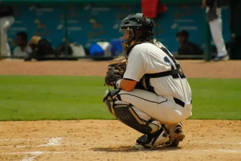 Kneeling baseball catcher.