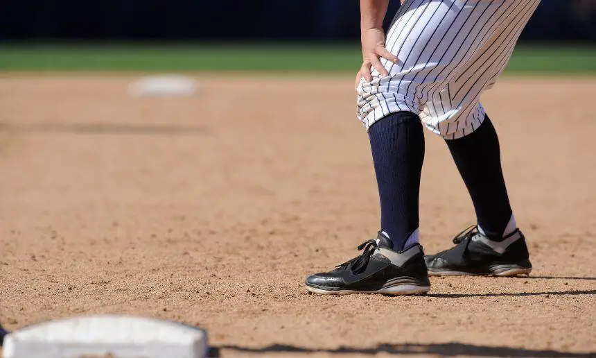 Player with baseball cleats stands at the base.