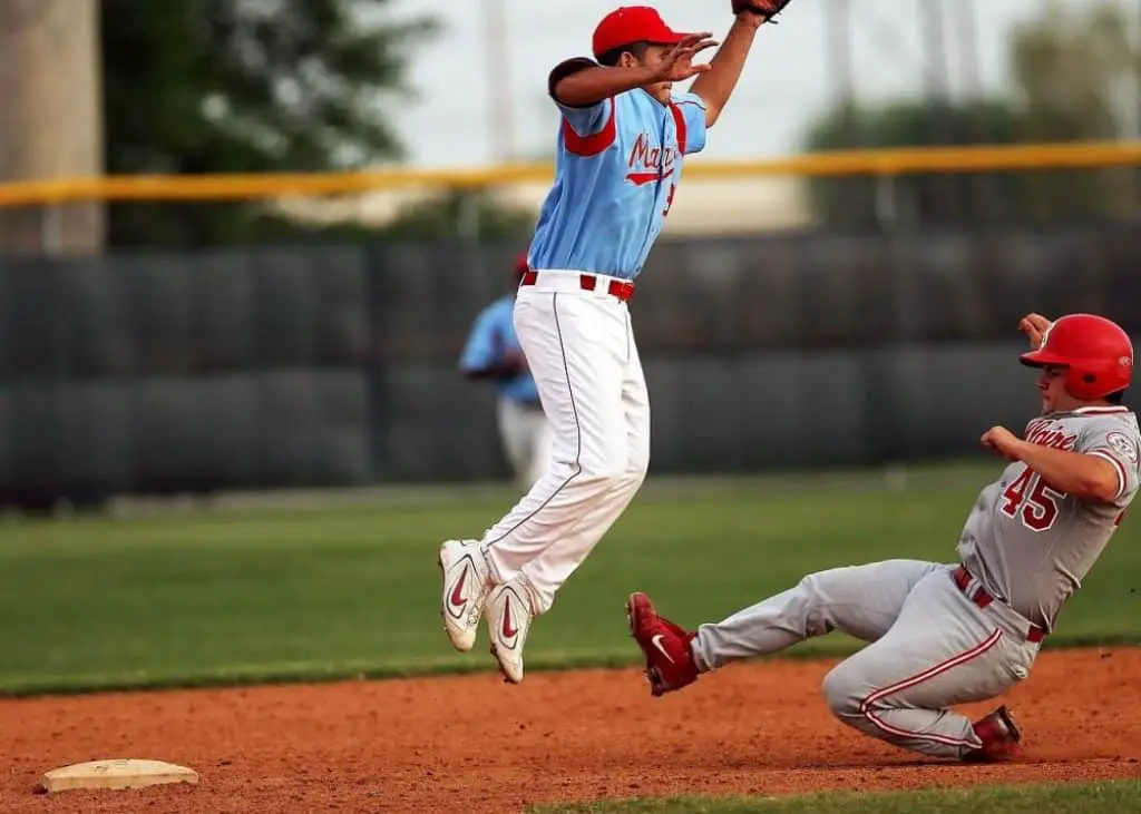 Baseball player, slides into base with foot outstretched.
