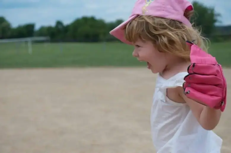 Little girl with softball glove.