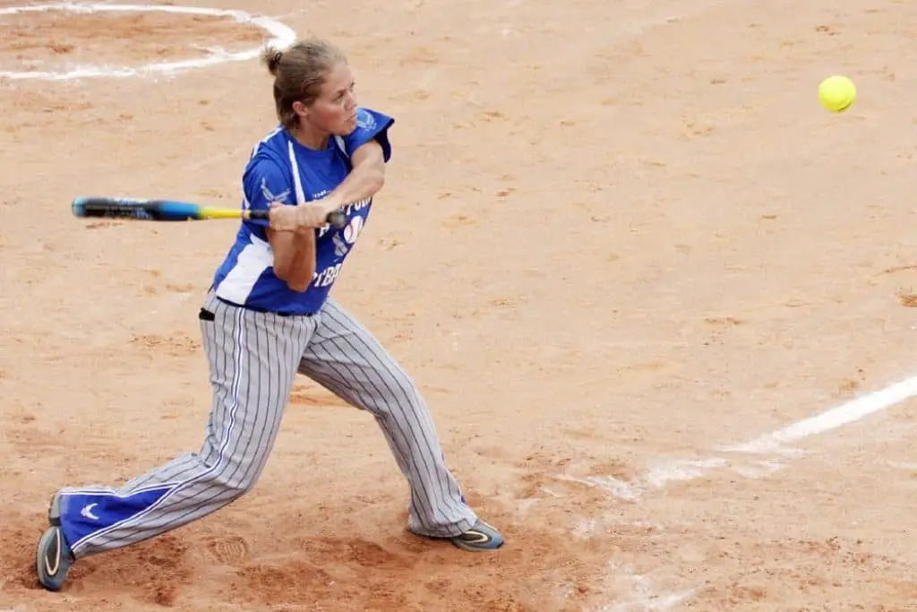 Female softball player batting a softball.