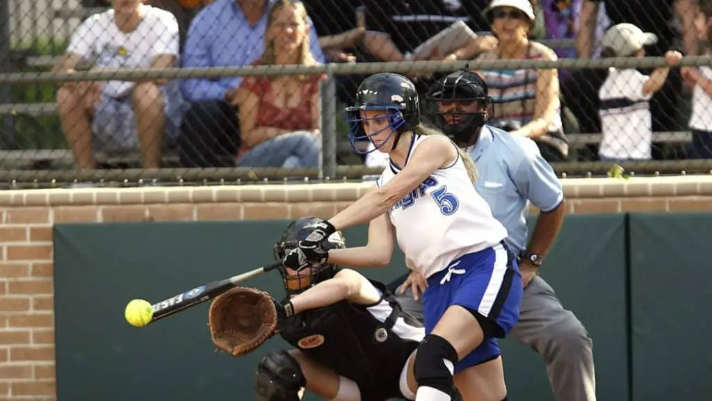 Female softball player hitting a softball.