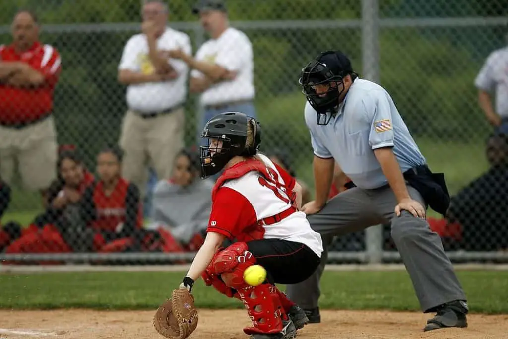 Softball umpire and catcher on home plate.