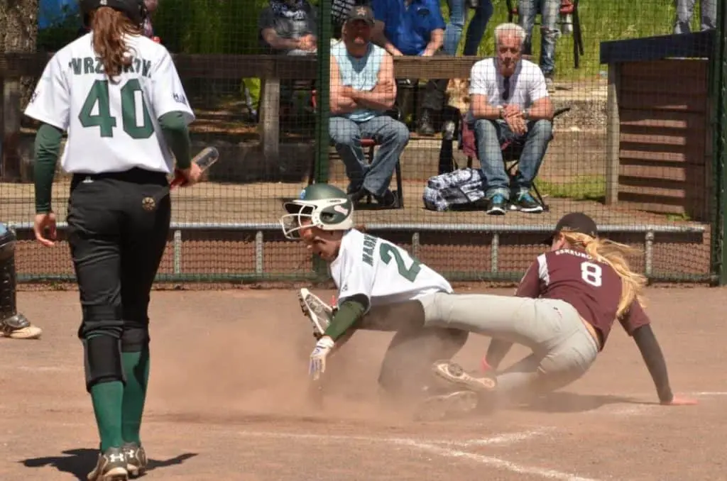 Female softball player sliding into the first base.