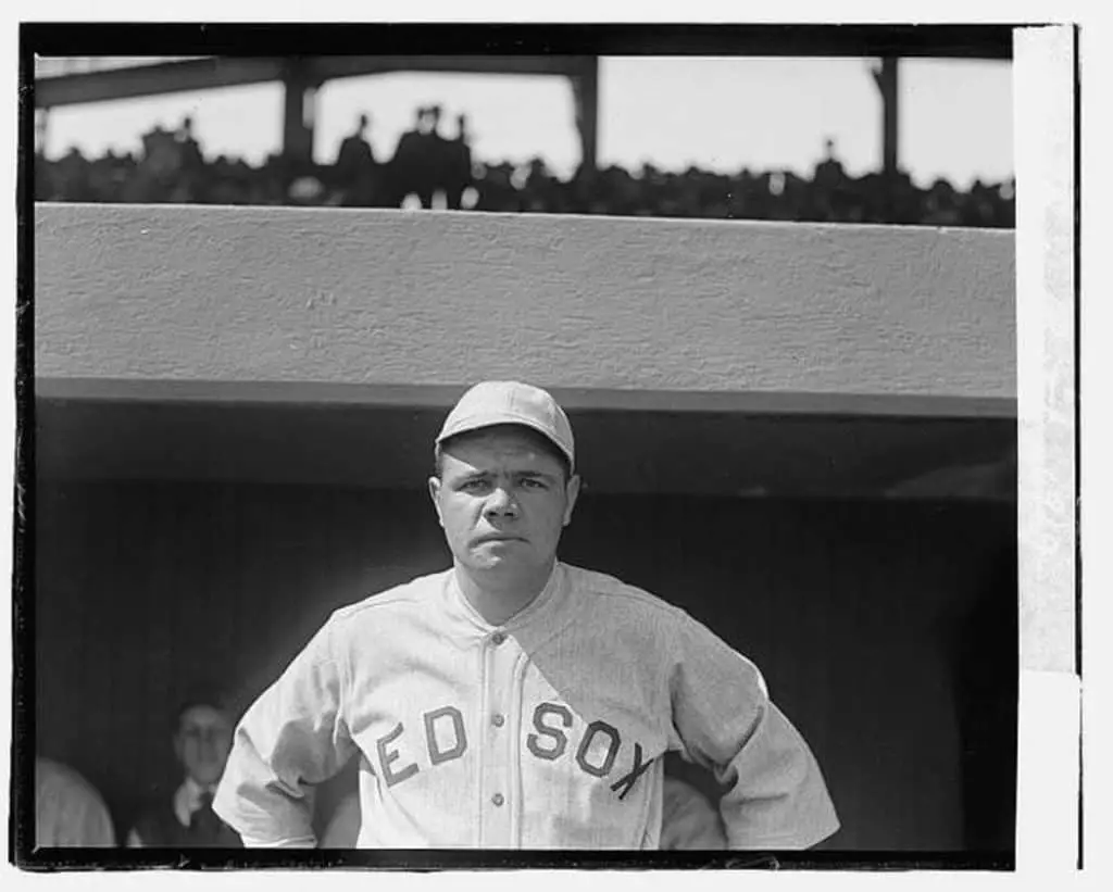 Babe ruth standing at home dugout.