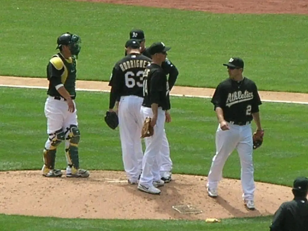 Baseball players from oakland athletics meet at the mound.