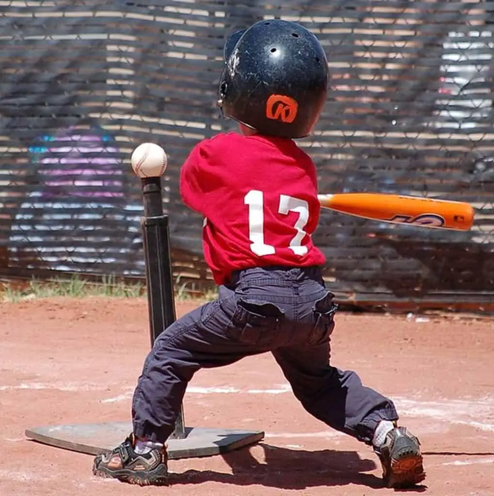 Children with t-ball bat trying to hit a ball.