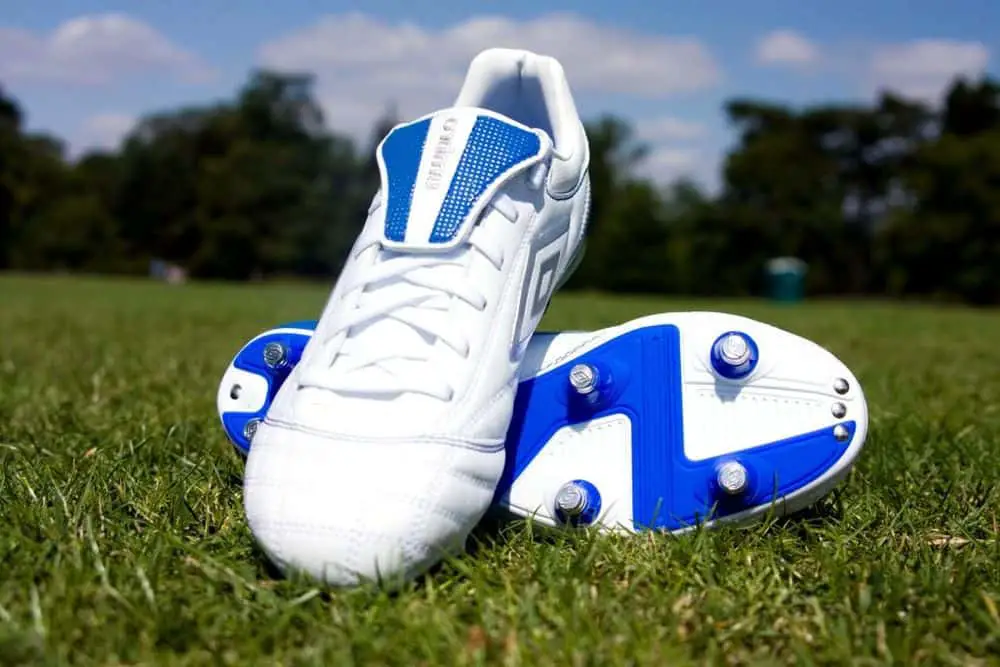 Football cleats lying on the green.