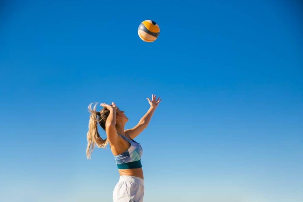 Female volleyball player hitting the ball.