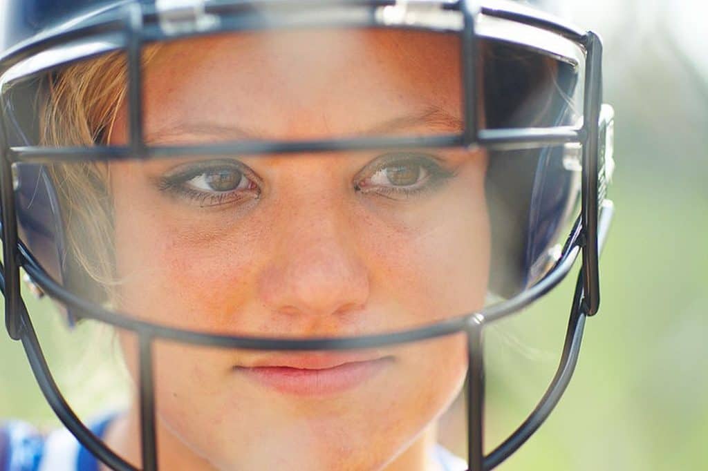 Female softball player with facemask.