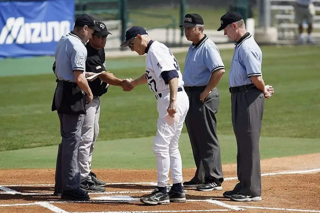 Baseball coaches and umpires meet before the game.