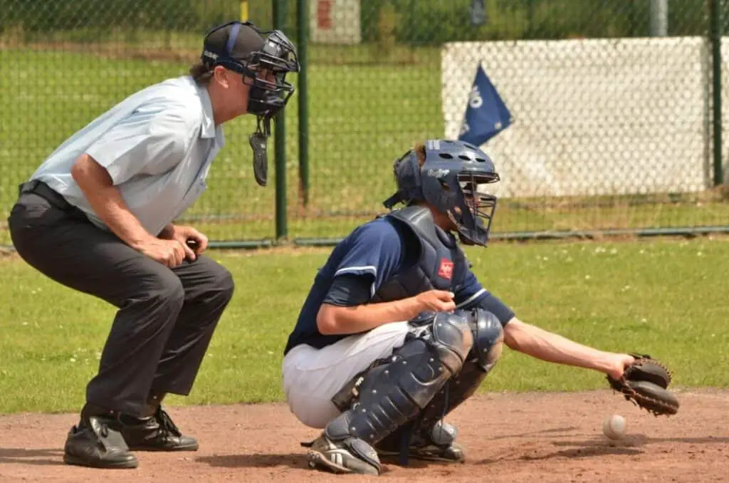 Kneeling catcher and umpire at home plate.